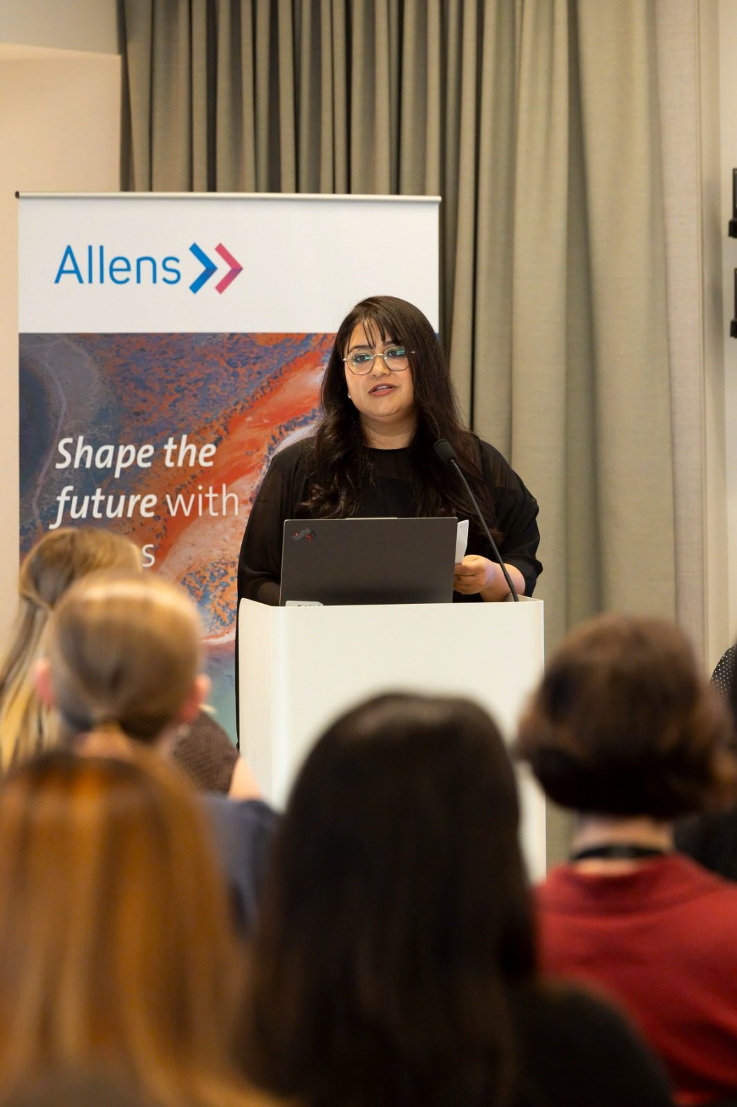 Dr Apurva Kirti Sharma (VWL Engagement Officer), the speaker stands at a podium and an audience.